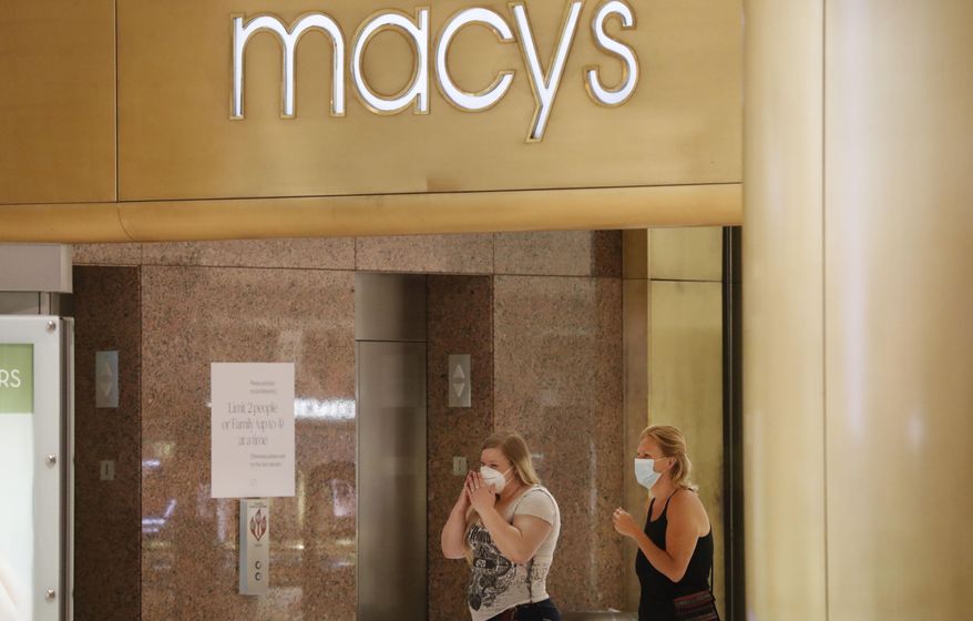 Amid concerns of the spread of COVID-19, shoppers wear masks while walking past a Macy's store at the Galleria Dallas mall in Dallas, Monday, May 4, 2020. (AP Photo/LM Otero)