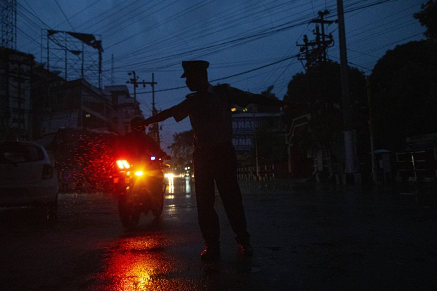 An Indian traffic police man stops a motorist during nationwide lockdown in Gauhati, India, Tuesday, May 5, 2020. India's six-week coronavirus lockdown, which was supposed to end on Monday, has been extended for another two weeks, with a few relaxations. Locking down the country's 1.3 billion people has slowed down the spread of the virus, but has come at the enormous cost of upending lives and millions of lost jobs. (AP Photo/Anupam Nath)