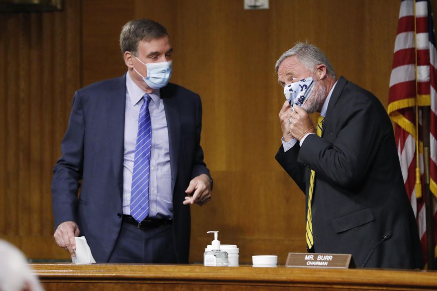 Senate Intelligence Committee Chairman Sen. Richard Burr, R-N.C. right, adjusts his mask while talking to Vice Chairman Sen. Mark Warner, D-Va., at the conclusion of a nomination hearing to consider Rep. John Ratcliffe, R-Texas, to be Director of National Intelligence, on Capitol Hill in Washington, Tuesday, May. 5, 2020. (AP Photo/Andrew Harnik, Pool)  **FILE**