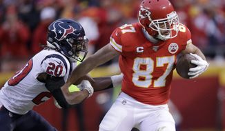 FILE - In this Jan. 12, 2020, file photo, Kansas City Chiefs tight end Travis Kelce (87) is tackled by Houston Texans safety Justin Reid during the second half of an NFL divisional playoff football game in Kansas City, Mo. Kelce has two years remaining on a five-year, $46.8 million extension that he signed in 2016. (AP Photo/Charlie Riedel, File)