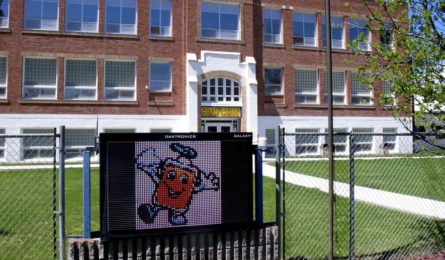 This Monday, May 4, 2020, file photo shows Willow Creek School in Willow Creek, Mont. The school with its 56 students will be among the first in the U.S. to reopen after being shut down due to the coronavirus concerns. Desks will be spaced 6 feet apart, temperatures will be checked upon arrival and any child not following social-distancing guidelines will be sent home, officials said. (AP Photo/Matt Volz)