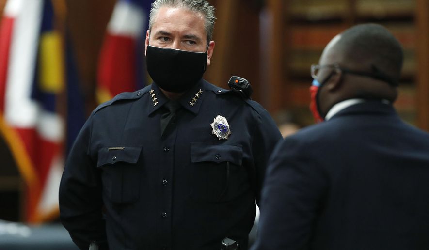 Denver Police Department Chief Paul Pazen, left, wears a face mask while waiting for Denver Mayor Michael Hancock to enter a news conference to explain the city&#x27;s plan to allow businesses to reopen as the city&#x27;s stay-at-home order to stem the rise of the new coronavirus expires later this week on Tuesday, May 5, 2020, in Denver. (AP Photo/David Zalubowski)