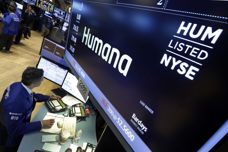 FILE - In this June 8, 2015, file photo specialist Anthony Rinaldi works adjacent to the post that handles Humana, on the floor of the New York Stock Exchange. Humana will pick up the tab for millions of customers when they are ready to ease COVID-19 social distancing and return to the doctor’s office. The insurer said Tuesday, May 5, 2020 that it is waiving deductibles and other out-of-pocket costs for all Medicare Advantage customers who visit their primary care doctor or see a behavioral health specialist. (AP Photo/Richard Drew, File)