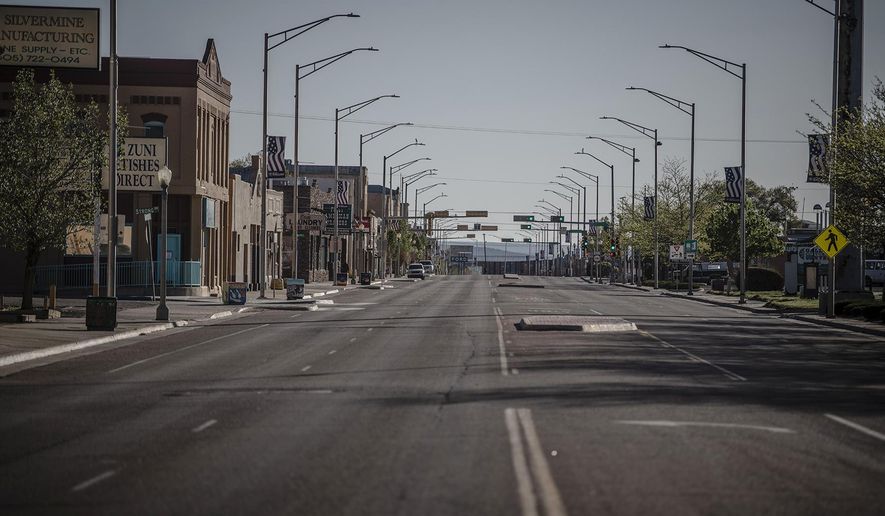 CORRECTS DATE MAY 1, NOT 5 - This Friday, May 1, 2020 photo shows a street in Gallup, N.M., following the governor's order to go in lockdown that started Friday. New Mexico Gov. Michelle Lujan Grisham is ordering workers at retail stores and restaurants to wear face coverings as a precaution against the spread of COVID-19, starting with larger retail stores and major grocery stores on Wednesday. (Roberto E. Rosales/The Albuquerque Journal via AP)