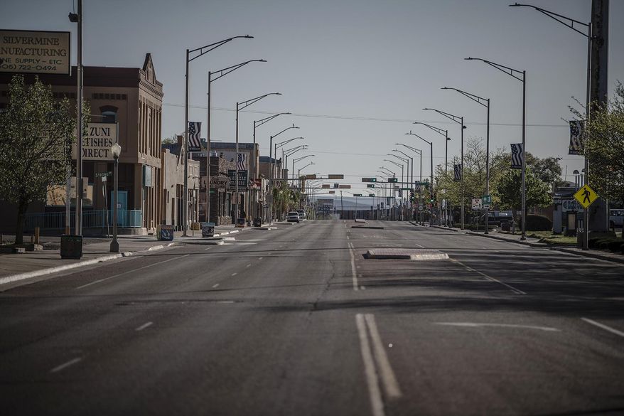 CORRECTS DATE MAY 1, NOT 5 - This Friday, May 1, 2020 photo shows a street in Gallup, N.M., following the governor's order to go in lockdown that started Friday. New Mexico Gov. Michelle Lujan Grisham is ordering workers at retail stores and restaurants to wear face coverings as a precaution against the spread of COVID-19, starting with larger retail stores and major grocery stores on Wednesday. (Roberto E. Rosales/The Albuquerque Journal via AP)