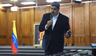 This photo released by the Venezuelan Miraflores presidential press office shows President Nicolas Maduro speaking over military equipment that he says was seized during an incursion into Venezuela, during his televised address from Miraflores in Caracas, Venezuela, Monday, May 4, 2020. Maduro said authorities arrested two U.S. citizens among a group of “mercenaries” on Monday, a day after a beach raid purportedly aimed at capturing the leader that Venezuelan authorities say they foiled. (Miraflores press office via AP)