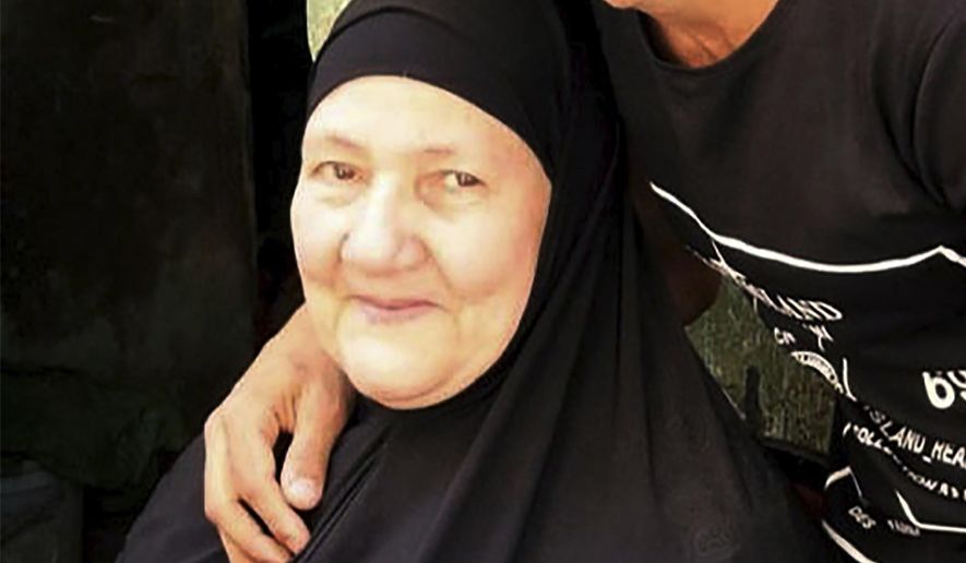 This undated handout image provided by the family of El-Sayed, shows Ghaliya Abdel-Wahab, who died from COVID-19 on April 6, 2020, poses for a photograph with her grandson, in the Shubra el-Kheima neighborhood, Qalyoubiya governorate, Egypt. The novel coronavirus struck her family with horrific speed, infecting 45 of her relatives. (El-Sayed family via AP)