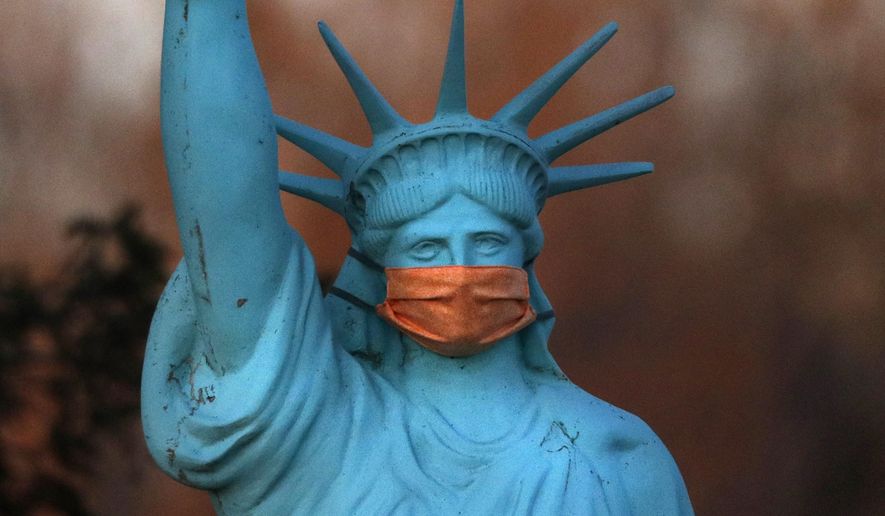 A replica of the Statue of Liberty wears a coronavirus mask outside a home on Deer Isle, Maine, Wednesday, May 6, 2020. (AP Photo/Robert F. Bukaty)
