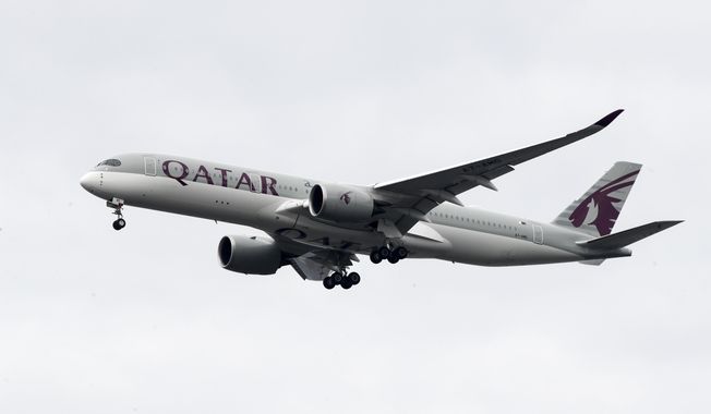 FILE - In this Nov. 7, 2019 file photo, a Qatar Airways jet approaches Philadelphia International Airport in Philadelphia. Long-haul carrier Qatar Airways said Wednesday, May 6, 2020, it will fire staff as the coronavirus pandemic largely has grounded the global aviation industry. (AP Photo/Matt Rourke, File)