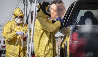 Medical personnel conduct drive-thru COVID-19 testing Monday afternoon May 4, 2020, at Rehoboth McKinley Christian Health Care Services in Gallup, N.M. (Roberto E. Rosales/The Albuquerque Journal via AP)