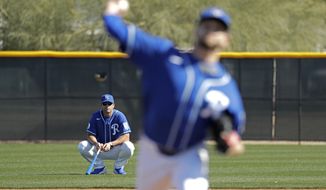 FILE - In this Feb. 16, 2020, file photo, Kansas City Royals manager Mike Matheny, back left, watches as pitcher Jesse Hahn throws during spring training baseball practice in Surprise, Ariz. The Royals had an entire offseason and most of spring training to get to know Mike Matheny. But one unintended consequence of the coronavirus pandemic is they&#x27;ve gotten to know their new manager better than they could ever have imagined. (AP Photo/Charlie Riedel, File)