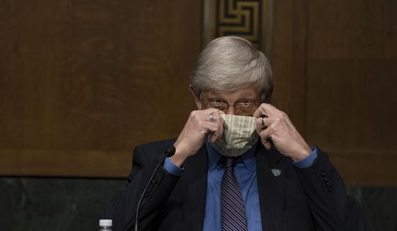 National Institutes of Health Director Dr. Francis Collins puts on his face mask after a Senate Health Education Labor and Pensions Committee hearing on new coronavirus tests on Capitol Hill in Washington, Thursday, May 7, 2020. (Anna Moneymaker/The New York Times via AP, Pool)