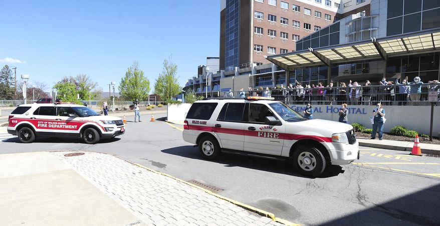 Commonwealth Health workers applaud and cheer honoring first responders from local fire companies, local and state police officers, and other community minded organizations during a parade, Thursday May 7, 2020, Wilkes-Barre, Pa., honoring our Commonwealth Health General Hospital, Geisinger South, Geisinger Wyoming Valley and the Veterans Administration Medical Center's front line workers. (Mark Moran/The Citizens' Voice via AP)