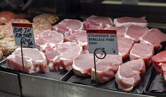 Fresh pork chops sit in a case for sale as shoppers look for items on their grocery lists amid the new coronavirus pandemic, Friday, May 8, 2020, at Rouses in Arlington Marketplace in Baton Rouge, La. (Hilary Scheinuk/The Advocate via AP)