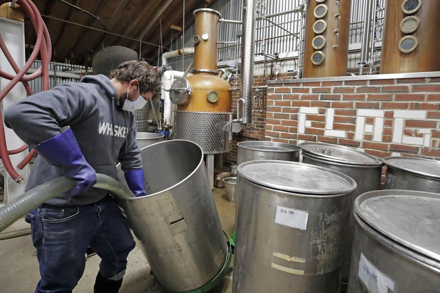 Owner and distiller Brian Ferguson loads a batch of alcohol into a still while making hand sanitizer at the Flag Hill Distillery in Lee, N.H., Friday, May 8, 2020. The distillery, which usually produces whisky, rum and vodka, temporarily suspended normal operations to manufacture hand sanitizer due to need during the COVID-19 virus outbreak. (AP Photo/Charles Krupa)