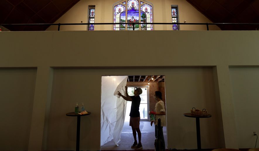 Alamo Heights Baptist Church pastor Bobby Contreras, left, and his wife Hannah, work to clean, sanitize and prepare the church for services this Sunday, in San Antonio, Wednesday, May 6, 2020,. Texas' stay-at-home orders due to the COVID-19 pandemic have expired and Texas Gov. Greg Abbott has eased restrictions on many businesses that have now opened, churches and places or worship may resume live services with 25% capacity. (AP Photo/Eric Gay)