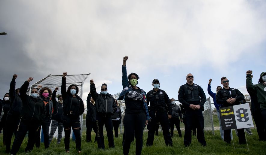 In this Friday, May 8, 2020 photo, a group of around 30 to 40 people participated in a 2.23 mile walk for Ahmaud Arbery in Ypsilanti, Mich. It was a symbolic gesture for Arbery who was shot and killed while running in Brunswick, Ga., on Feb. 23, 2020. (Nicole Hester\/Ann Arbor News via AP)