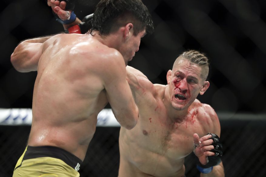 Niko Price, right, throws a punch to Vicente Luque during a UFC 249 mixed martial arts bout, Saturday, May 9, 2020, in Jacksonville, Fla. (AP Photo/John Raoux)