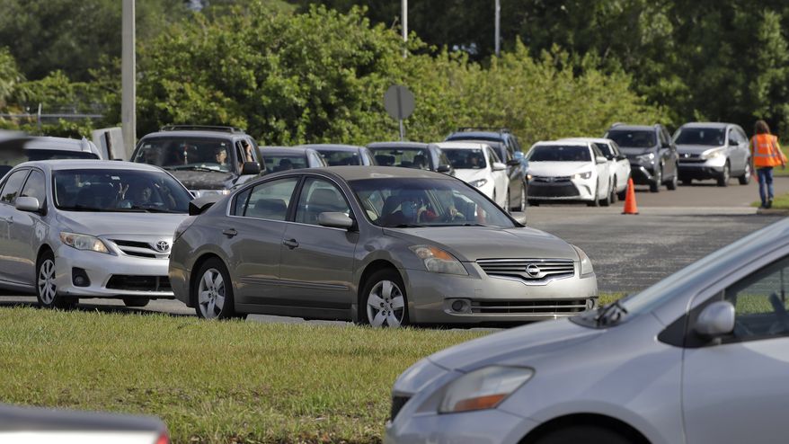 Cars line up for Feeding Tampa Bay's Mega Food Pantry food distribution at the Hillsborough Community College Saturday, May 9, 2020, in Tampa, Fla. The group intends to give out more than 3,500 meals to the public struggling from the effects of the coronavirus. (AP Photo/Chris O'Meara)