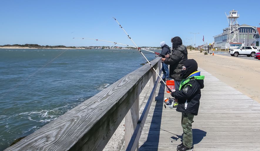 Visitors at the boardwalk at Ocean City, Md., fish while standing six feet apart to follow social distancing guidelines. The resort town reopened its beach and boardwalk on Saturday, May 9, 2020. (Photo by All-Pro Reels / Ed Sheahin)