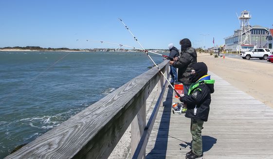 Visitors at the boardwalk at Ocean City, Md., fish while standing six feet apart to follow social distancing guidelines. The resort town reopened its beach and boardwalk on Saturday, May 9, 2020. (Photo by All-Pro Reels / Ed Sheahin)