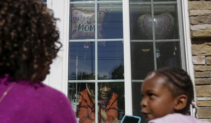 Mary Washington, 73, speaks through a window to her daughter, Courtney Crosby and grandchild Sydney Crosby for a Mother's Day celebration at Provident Village at Creekside senior living on Sunday, May 10, 2020, in Smyrna, Ga. (AP Photo/Brynn Anderson)