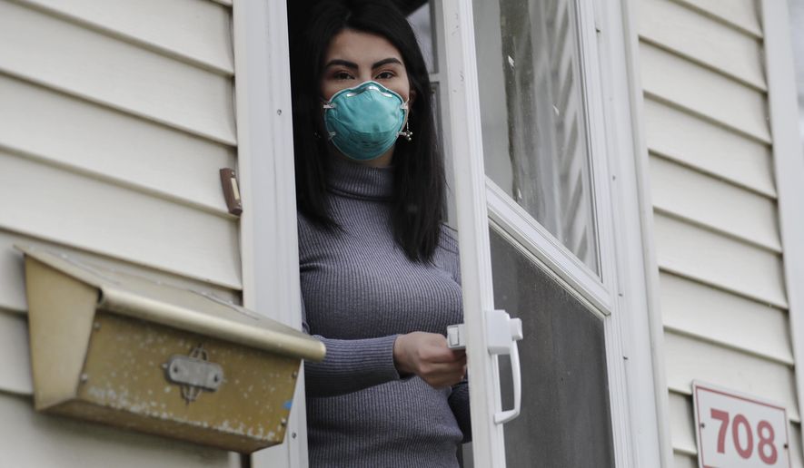 Francy Sandoval poses for a portrait at her home in Melrose Park, Ill., Thursday, April 23, 2020. She works as a receptionist at a community health clinic which treats multiple COVID-19 cases. She has to isolate herself in the attic as soon as she comes home from work each day and is terrified of infecting her family. (AP Photo/Nam Y. Huh)