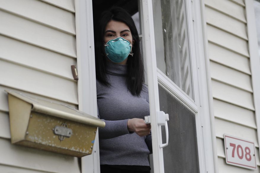 Francy Sandoval poses for a portrait at her home in Melrose Park, Ill., Thursday, April 23, 2020. She works as a receptionist at a community health clinic which treats multiple COVID-19 cases. She has to isolate herself in the attic as soon as she comes home from work each day and is terrified of infecting her family. (AP Photo/Nam Y. Huh)