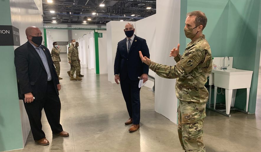 (From left) John Falcicchio, D.C.&#x27;s acting deputy for planning and economic development; Chris Geldart, acting director of D.C.&#x27;s Department of Public Works; and Col. John Litz, commander of the Baltimore District of the Army Corps of Engineers, give a tour of the 437-bed alternate care facility at The Washington E. Convention Center in the District on Monday. (Sophie Kaplan/The Washington Times)