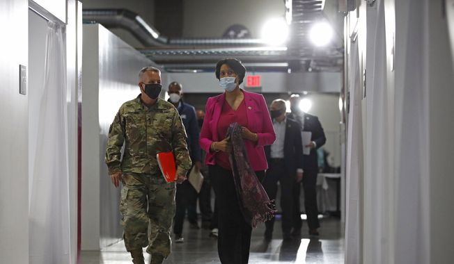 Lt. Gen. Todd Semonite, left, commanding general of the U.S. Army Corps of Engineers, departs a news conference with District of Columbia Mayor Muriel Bowser at a temporary alternate care site constructed in response to the coronavirus outbreak inside the Walter E. Washington Convention Center in Washington, Monday, May 11, 2020. (AP Photo/Patrick Semansky)  **FILE**
