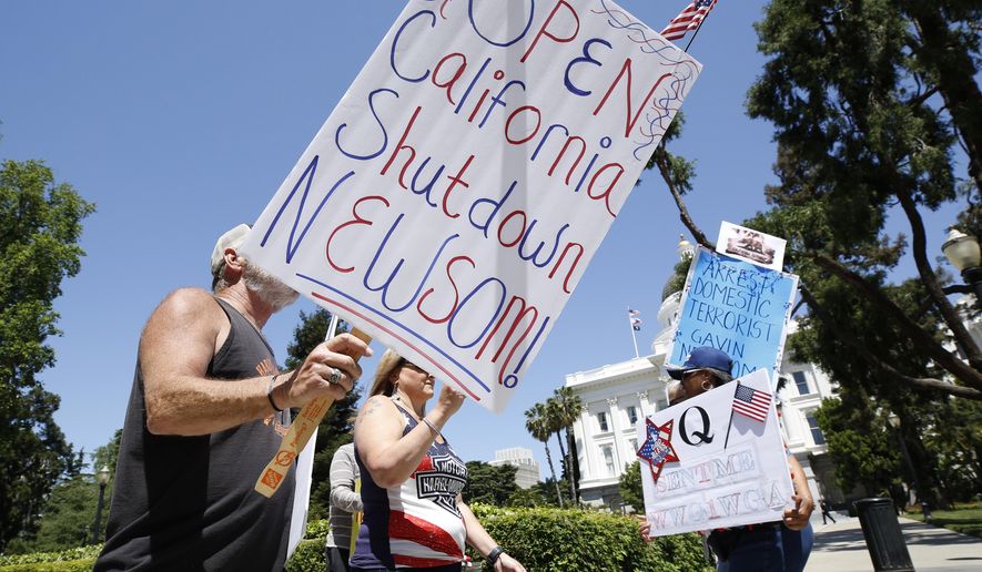 FILE - In this May 1, 2020, file photo protesters calling for the end of Gov Gavin Newsom's stay-at-home orders march around the state Capitol in Sacramento, Calif. More Americans disapprove than approve of protests that have taken place across the country against restrictions put in place to prevent the spread of COVID-19, according to a new poll by The University of Chicago Divinity School and The Associated Press-NORC Center for Public Affairs Research. (AP Photo/Rich Pedroncelli, File)