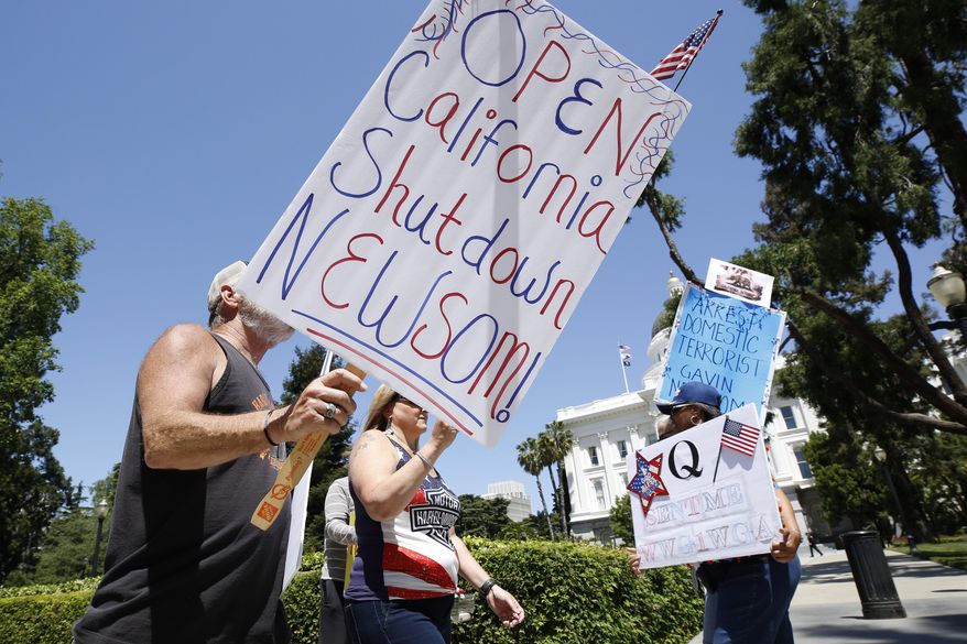 FILE - In this May 1, 2020, file photo protesters calling for the end of Gov Gavin Newsom's stay-at-home orders march around the state Capitol in Sacramento, Calif. More Americans disapprove than approve of protests that have taken place across the country against restrictions put in place to prevent the spread of COVID-19, according to a new poll by The University of Chicago Divinity School and The Associated Press-NORC Center for Public Affairs Research. (AP Photo/Rich Pedroncelli, File)