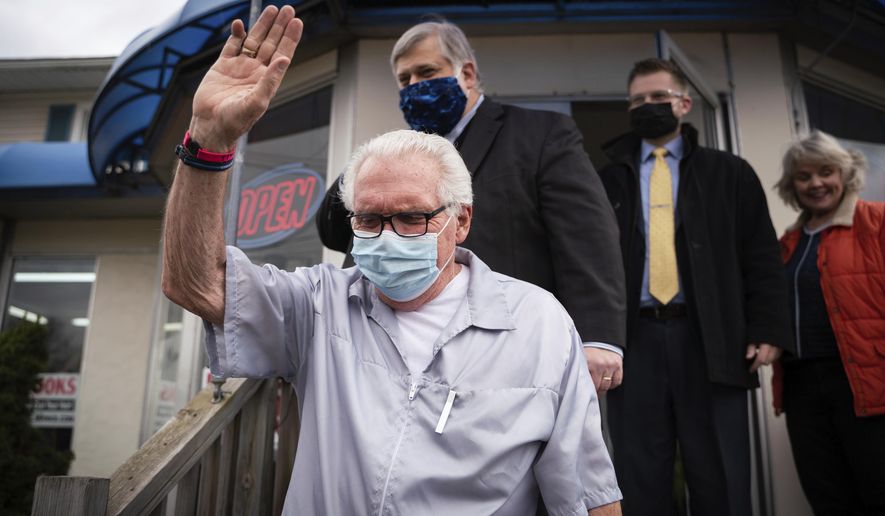 Karl Manke, 77, waves to people gathered just before a press conference on Monday, May 11, 2020 at Karl Manke&#39;s Beauty &amp;amp; Barber Shop in Owosso, Mich. Manke has defied the governor&#39;s order not to conduct business. (Sarahbeth Maney/The Flint Journal via AP)