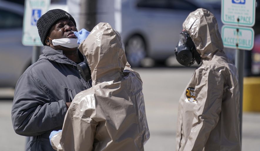 Wisconsin National Guard members administer COVID-19 tests in a parking lot Monday May 11, 2020, in Milwaukee. This was one of two sites in the city to open Monday and offer free testing. (AP Photo/Morry Gash)