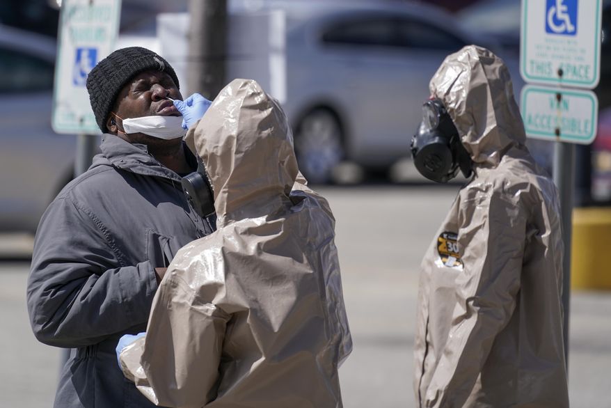 Wisconsin National Guard members administer COVID-19 tests in a parking lot Monday May 11, 2020, in Milwaukee. This was one of two sites in the city to open Monday and offer free testing. (AP Photo/Morry Gash)