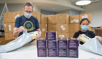 JOOLA employees John Miller and Caroline Kajihahra prepare a shipment of face masks at the company&#39;s headquarters in Rockville, Maryland. The table tennis supply distributor has sold more than 3 million masks to health care providers. (JOOLA)