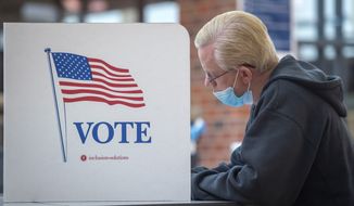 Chuck Schweitzer votes with a mask at a voting booth during Nebraska primary election in Lincoln, Neb., Tuesday, May 12, 2020. (Justin Wan/Lincoln Journal Star via AP)  **FILE**