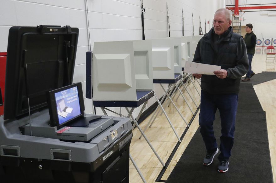 Mark Spear makes his way to the voting machine after filling out his ballot during a special election for Wisconsin&#39;s 7th Congressional District on Tuesday, May 12, 2020, at Wausau East High School in Wausau, Wis. Republican Tom Tiffany and Democrat Tricia Zunker are vying to fill the vacancy left by Republican Sean Duffy, who resigned from the seat in September. (Tork Mason/The Post-Crescent via AP)