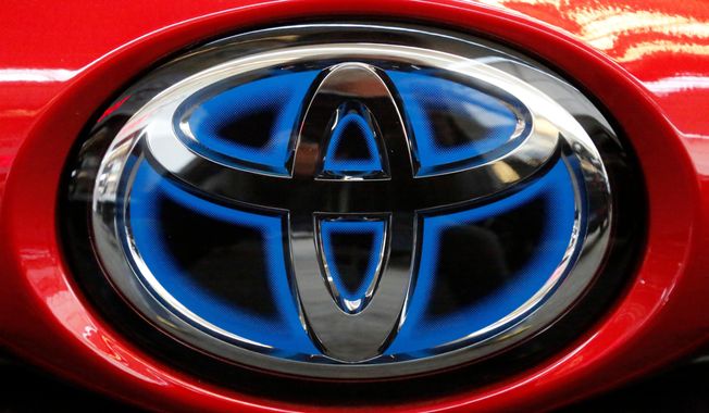 FILE- This Feb. 15, 2018, file photo shows the Toyota logo on the trunk of a 2018 Toyota Prius on display at the Pittsburgh Auto Show. Toyota Motor Corp. reported Tuesday, May 12, 2020 a sharp plunge in fiscal fourth quarter profit as the global pandemic slammed vehicle sales and halted production at its auto plants. (AP Photo/Gene J. Puskar, File)