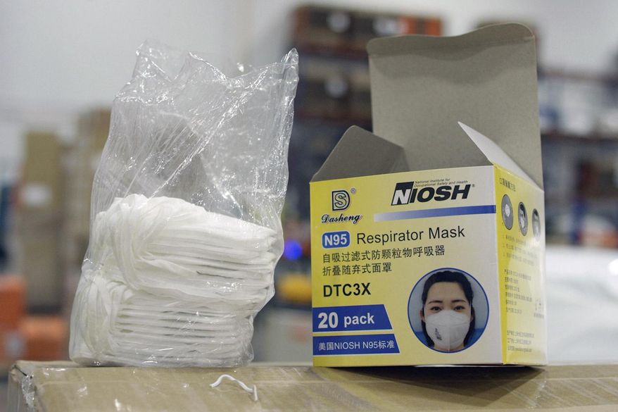 An opened box of protective masks sits on a pallet at Direct Relief's distribution center in Santa Barbara, Calif., on Wednesday, April 1, 2020. An Associated Press investigation has found millions of medical masks, gloves, gowns and other supplies being used in hospitals across the country are counterfeits, putting lives at risk. (Jonathan Ingalls/FRONTLINE/PBS/GRC via AP)