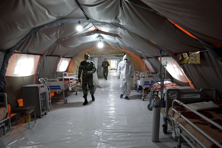In this March 26, 2020, file photo, Iranian army soldiers work in a temporary 2,000-bed hospital for coronavirus patients set up by the army at the International Exhibition Center in northern Tehran, Iran. Dozens of medical staffers have died of COVID-19 in Iran. Doctors and nurses and other staffers have been hard hit. During the first 90 days of the virus outbreak alone, about one medical staffer died each day. (AP Photo/Ebrahim Noroozi, File)