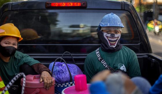 Construction workers wearing face masks travel in a back of a crew cab in Bangkok, Thailand, Wednesday, May 13, 2020. Thai government continue to ease restrictions related to running business in capital Bangkok that were imposed weeks ago to combat the spread of COVID-19. (AP Photo/Gemunu Amarasinghe)