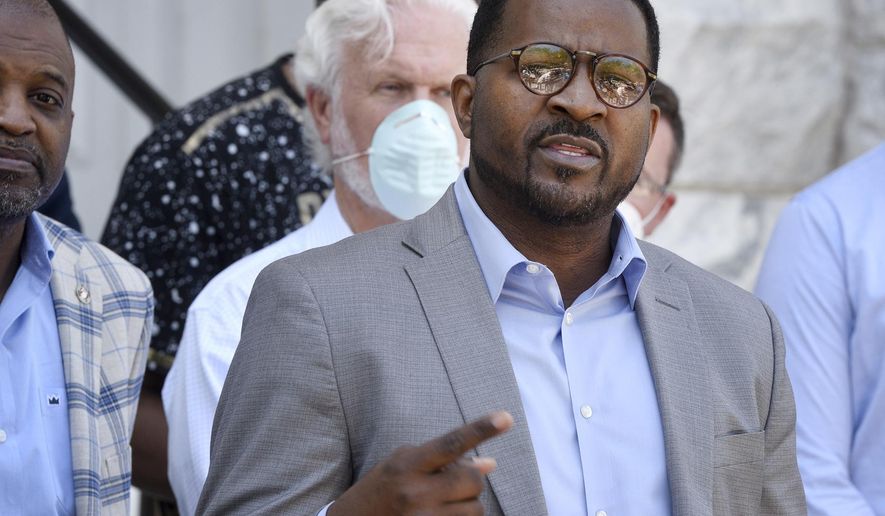 In this May 6, 2020, photo, flanked by area ministers, the Rev. John Perry III, president of the Brunswick, Ga., NAACP, addresses members of the media in front of old city hall. The people who call Brunswick home say it’s not the monstrous place it might appear to be in the wake of the slaying of Ahmaud Arbery after a pursuit by two armed white men. Perry was “pleasantly surprised that the people here have a great heart,” he said. (Bobby Haven/The Brunswick News via AP)
