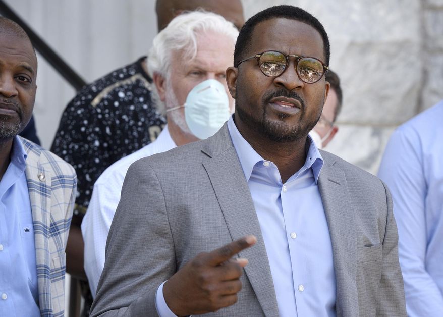 In this May 6, 2020, photo, flanked by area ministers, the Rev. John Perry III, president of the Brunswick, Ga., NAACP, addresses members of the media in front of old city hall. The people who call Brunswick home say it’s not the monstrous place it might appear to be in the wake of the slaying of Ahmaud Arbery after a pursuit by two armed white men. Perry was “pleasantly surprised that the people here have a great heart,” he said. (Bobby Haven/The Brunswick News via AP)