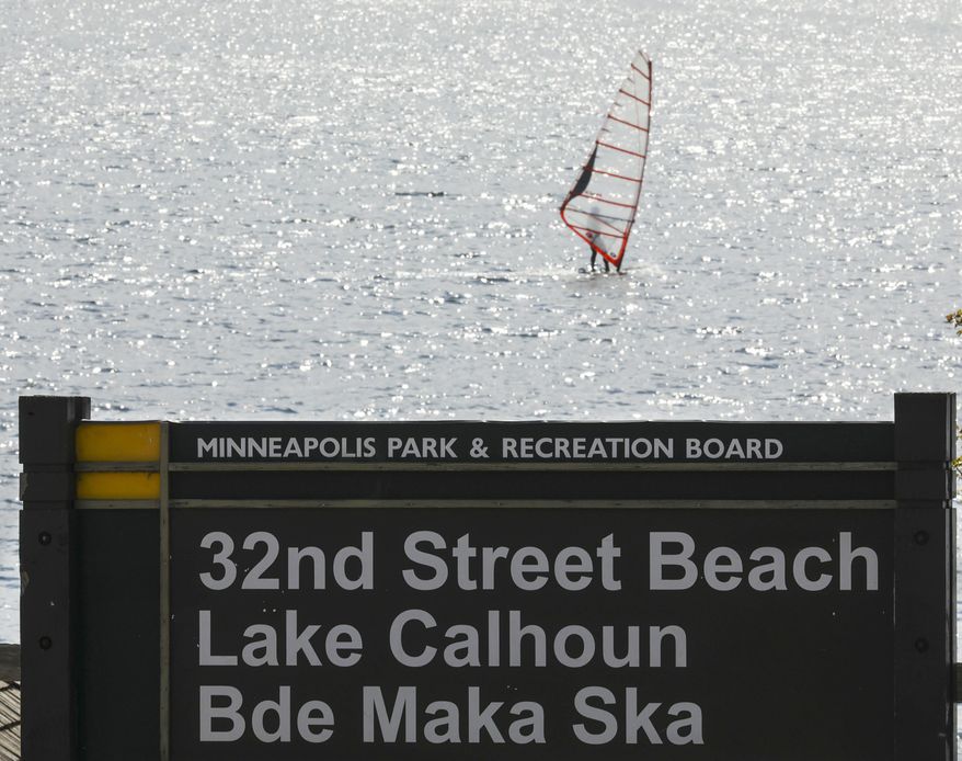 FILE - In this May 2, 2017 file photo, a windsurfer glides on the surface of Lake Calhoun in Minneapolis. A divided Minnesota Supreme Court said Wednesday, May 12, 2020, that the state Department of Natural Resources has the authority to change the name of a popular lake, Lake Calhoun, back to its original Dakota name, Bde Maka Ska. (Jeff Wheeler/Star Tribune via AP, File)