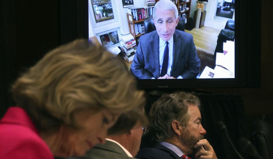 Senators listen as Dr. Anthony Fauci, director of the National Institute of Allergy and Infectious Diseases, speaks remotely during a virtual Senate Committee for Health, Education, Labor, and Pensions hearing, Tuesday, May 12, 2020 on Capitol Hill in Washington. Seated from left are Sen. Lisa Murkowski, R-Alaska, Sen. Mike Braun, R-Ind., center, and Sen. Rand Paul, R-Ky. (Win McNamee/Pool via AP)