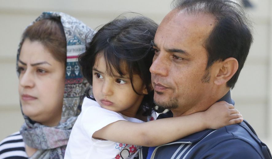 In this April 22, 2020, photo, Afghan refugee Mahmood Amiri poses with daughter Safa, and his wife Masouda, in West Valley City, Utah. Coronavirus restrictions have affected refugee families in the same ways as anyone else — job losses, child care challenges — but many are navigating the turmoil in a language they don't fully understand and without extended family or close friends to help. Amiri arrived in the United States more than a month ago, but his children are still waiting for their first day at school and the family has yet to go to the mosque to meet fellow Muslim families. (AP Photo/Rick Bowmer)