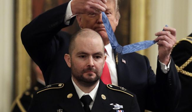 FILE - In this Oct. 1, 2018, file photo, President Donald Trump awards the Medal of Honor to former Army Staff Sgt. Ronald J. Shurer II for actions in Afghanistan, in the East Room of the White House in Washington. Shurer has died at age 41. Miranda Shurer said her husband, who was diagnosed with cancer three years ago, died Thursday, May 14, 2020, in a Washington, D.C., hospital. (AP Photo/Evan Vucci, File)