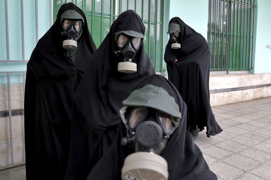 Cleric women wearing protective clothing and "chador," a head-to-toe garment, arrive a cemetery to prepare the body of a victim who died from the new coronavirus for a funeral, in the city of Ghaemshahr, in the north of Iran, Thursday, April 30, 2020. (AP Photo/Ebrahim Noroozi) ** FILE **