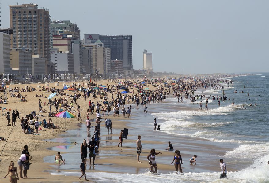 Warm weather draws crowds to the oceanfront, Saturday, May 16, 2020, in Virginia Beach, Va. (Kaitlin McKeown/The Daily Press via AP)